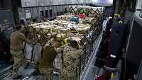 Soldaten verladen Transportpaletten mit Kisten in ein Transportflugzeug vom Typ A400M