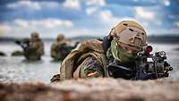 Soldiers in camouflage on position on a beach.