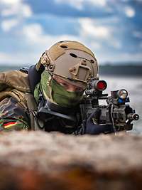 Soldiers in camouflage on position on a beach.