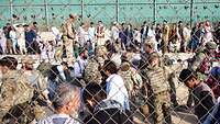 Soldaten kontrollieren Person in einem eingezäunten Zugangsbereich am Flughafen in Kabul