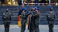 Mehrere Soldatinnen und Soldaten halten eine Bundesdienstflagge