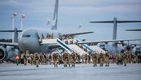 Viele Soldaten verlassen ein Transportflugzeug und laufen auf dem Flugfeld am Fliegerhorst in Wunstorf