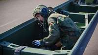 Eine Soldatin befestigt Spanngurte an einem Brückenlegesystem 