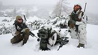 Drei Soldaten mit einem optoelektronischen Beobachtungsgerät im verschneiten Gelände