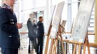 Soldiers looking at the caricatures, which are displayed on easels