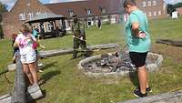 Kinder backen Stockbrot am Lagerfeuer