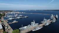 Zahlreiche Kriegsschiffe liegen bei gutem Wetter an der Pier im Hafen von Kiel.