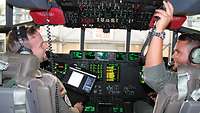 Zwei Soldaten sitzen im Cockpit einer C-130J