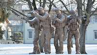Ein Statue von vier Soldaten mit Waffen im Anschlag