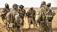 Deutsche und nigrische Soldaten stehen zusammen und besprechen sich