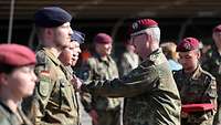 Der Generalinspekteur der Bundeswehr überreicht eine Einsatzmedaille an einen Soldaten. 