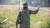 Ein Soldat misst mit einem Gerät die Windstärke