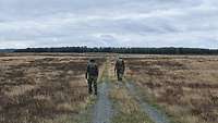 Zwei Soldaten suchen den Feldweg nach Sprengfallen ab.