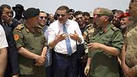 Der Libysche Premierminister redet inmitten einiger Soldaten.