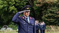 Ein General in blauer Uniform grüßt militärisch.
