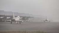 Zwei Eurofighter rollen im Nebel zur Startbahn