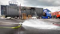 Sattelschlepper mit aufliegendem Container, bei dem an der Seite eine Tür geöffnet ist.