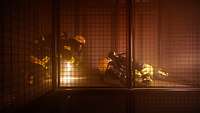 Feuerwehrmann zwängt sich in voller Ausrüstung durch eine Engstelle in einem Gitterkäfig.