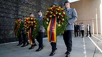 Soldaten mit Kränzen in den Händen am Ehrenmal der Bundeswehr, AKK, Steinmeier und Zorn folgen im Hintergrund