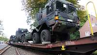 Ein LKW steht auf einem Flachwagen der Deutschen Bahn.