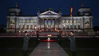 Soldaten mit Fakeln stehen am Abend vor dem Bundestag