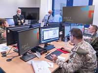 Soldaten arbeiten an ihren Computern und einige stehen dahinter.