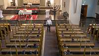 Eine Person steht in der Synagoge. Auf den Bänken sitzen mehrere Soldaten.