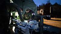 Zwei Soldaten verpacken medizische Geräte in Transportkisten