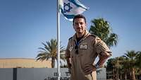Ein Soldat steht vor einer israelischen Flagge