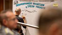 Graphic Recorder Tom Fiedler zeichnet die wichtigsten Punkte des Implementationslabors auf eine Tafel