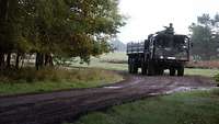 Ein LKW der Bundeswehr fährt durch Matsch.