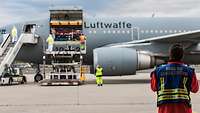 Ein Sanitäter mit Warnweste „ORGL RD Bundeswehr“ in Rückenansicht steht vor einem Airbus A310 MRTT MedEvac