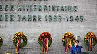 Annegret Karmp-Karrenbauer steht am Rednerpult vor der Gedenkstätte.