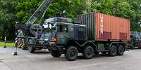 Ein Lkw UTF mit Container steht vor einem Kranwagen