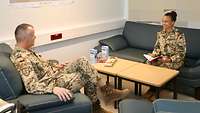 Eine Frau in Uniform sitzt auf einer Couch und berät den Kontingentführer. Dieser sitzt vor ihr auf einem Sessel.