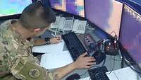 Ein libanesischer Soldat sitzt an einem Schreibtisch und hat mehrere Bildschirme vor sich