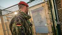 Ein Soldat steht vor einem Diensthunde-Warnschild an einer Gittertür