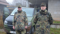 Ein älterer und ein jüngerer Soldat stehen vor einem Kleinbus der Bundeswehr.