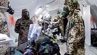 CBRN defense soldiers in protective suits detoxify an injured person