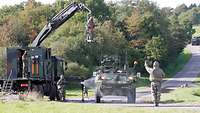 CBRN defense soldiers detoxify an armored vehicle