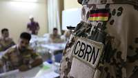 A German soldier teaches Iraqi soldiers.