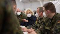 Verteidigungsministerin Lambrecht am Tisch sitzend im Gespräch mit mehreren Soldaten