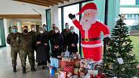 Viele Personen mit Geschenken unter einem Weihanchstbaum