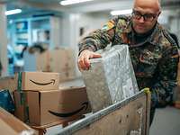 Ein Soldat holt ein Paket aus einer Paketbox heraus