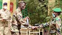 Ein malischer Soldat überreicht einer malischen Soldatin eine Urkunde