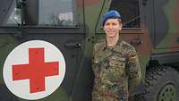 Ein Soldat steht neben einem Roten Kreuz eines Sanitätsfahrzeugs