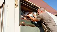 Ein Soldat repariert eine technische Anlage in einem Container 