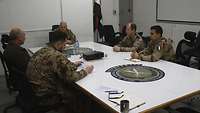 Fünf internationale Soldaten in einem Besprechungsraum