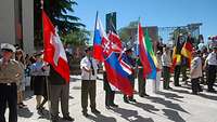 Soldaten verschiedener Nationen präsentieren ihre Landesflaggen