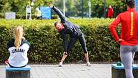 Sportlerinnen und Sportler beim Training draußen.